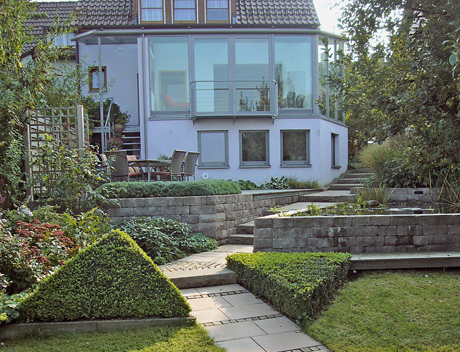 Gartenmauer SANTURO Weinbergmauer in der Farbe Naturgrau im Gartenbereich eines Grundstücks als Teichumrandung und als Abgrenzung zur Terrasse