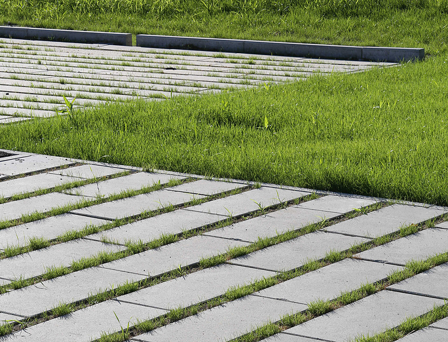 ökologischer Pflasterstein SPIRELL Längsrasenfugenstein in der Farbe Naturgrau als Parkplatzfläche verlegt