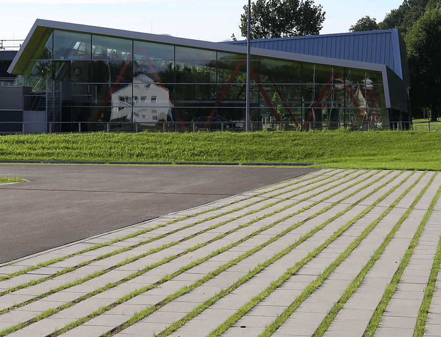 Parkplatzgestaltung mit Pflasterstein SPIRELL Längsrasenfugenstein in der Farbe Naturgrau